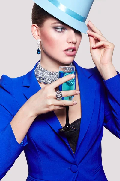 Chica hermosa joven de moda en una chaqueta azul con un cóctel . — Foto de Stock