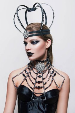 Alışılmadık bir taç mücevher ve büyük bir kolye ile bir kızla.