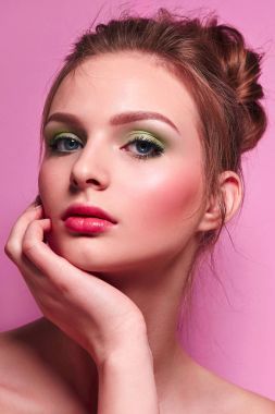 Çiçekli sarı ormangülü çalılar çerçevede akan dalgalı kumral standları ile güzel bir genç kız. Doğal makyaj, kırmızı dudaklar. Kabarık elbise. Güzellik. Sağlık, moda. Doğa.