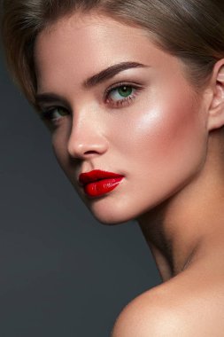 Stüdyoda gri arka planda güzel bir genç kadın var. Yakın plan portre. Saç stili.