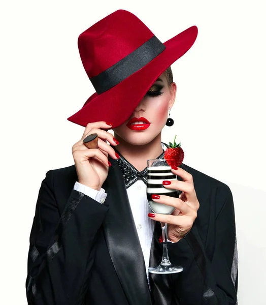 バーガンディの帽子を被った女の子が顔を覆っている 彼女の手にカクテルのガラスを持つ少女 ファッション アクセサリー 美容室 化粧品 化粧品 ロイヤリティフリーのストック写真