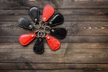 Keys attached to leather keychain , on wooden background clipart
