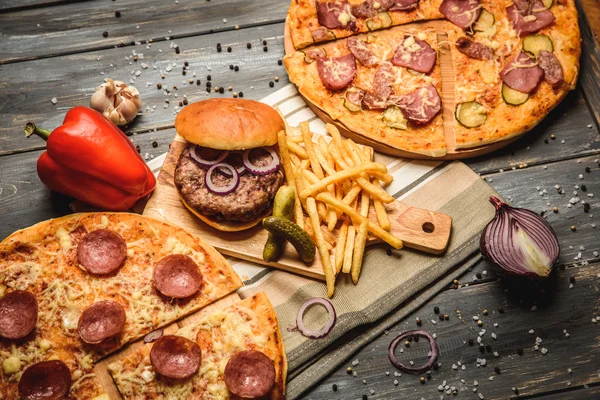 Pizza ve hamburger ahşap arka plan üzerinde