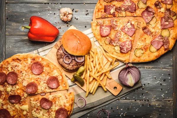 Pizza ve hamburger ahşap arka plan üzerinde