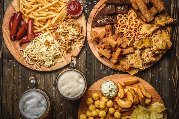 Snacks para cerveza sobre fondo de madera vista superior — Foto de Stock