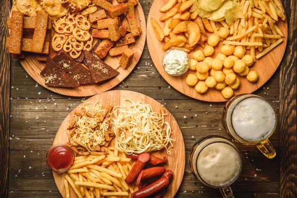 Snacks para cerveza sobre fondo de madera vista superior — Foto de Stock