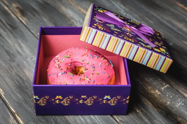 Donut de colores en una hermosa caja de regalo púrpura — Foto de Stock