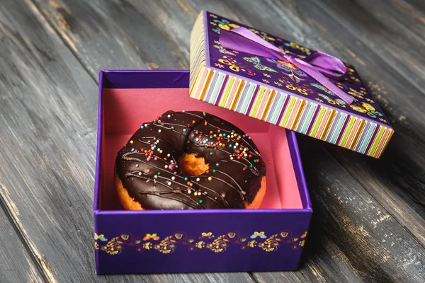 Donut de colores en una hermosa caja de regalo púrpura — Foto de Stock