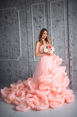Güzel genç kız kadar dalgalı saçlı pembe elbise-bulut içinde bir buket çiçek tutan iç olduğunu