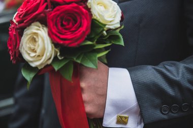 Beyaz papatya, erkek elinde çiçek bir buket tutan damat