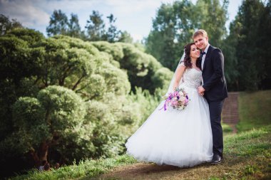 Gelin ve damat öpüşme doğada, güzel buket güneşli bir gün