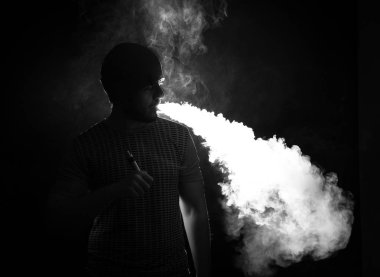 Sakal vaping şapkalı siyah arka plan üzerine erkeklerle