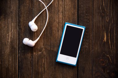 beyaz kulaklık ve ahşap arka plan mavi müzik çaların