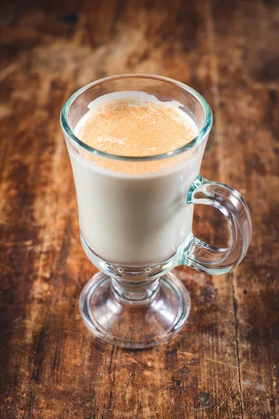 Latte im hohen Glasbecher auf Holztisch — Stockfoto