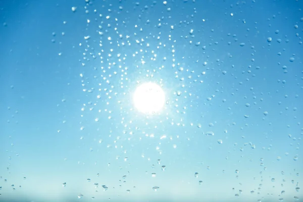 Wassertropfen auf Glas mit blauem Himmel Hintergrund — Stockfoto