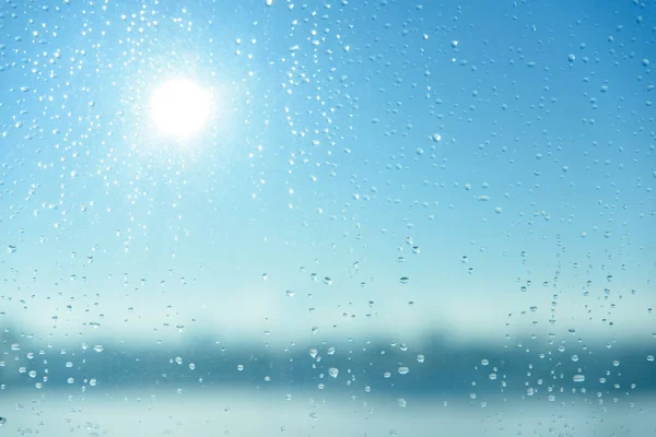 Wassertropfen auf Glas mit blauem Himmel Hintergrund — Stockfoto