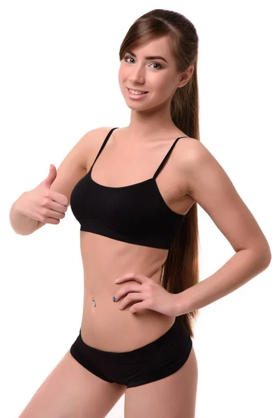 Mulher fitness feliz mostrando polegar para cima isolado em um fundo branco e olhando para a câmera — Fotografia de Stock
