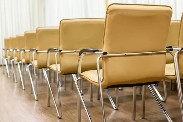 satır boş bir odada toplantısında metal sandalye. Arkadan Görünüm