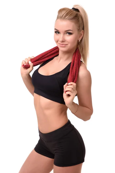 Hermosa chica deportiva después de un entrenamiento, sosteniendo sobre los hombros la toalla roja fondo blanco — Foto de Stock