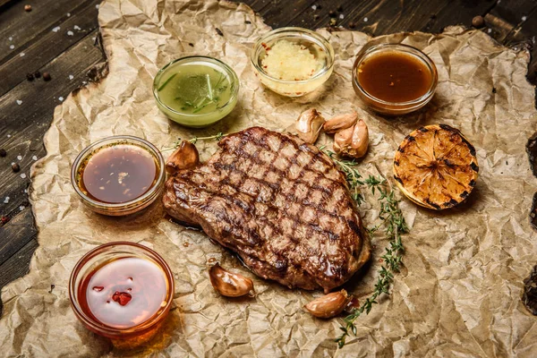 grilled steak with different sauces, on parchment. vertical top view
