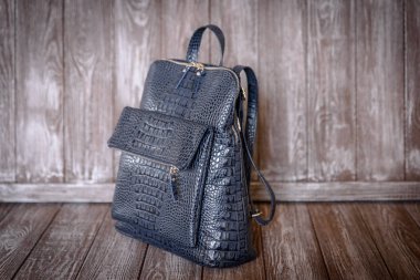 kahverengi ahşap zemin üzerinde mavi deri çanta.