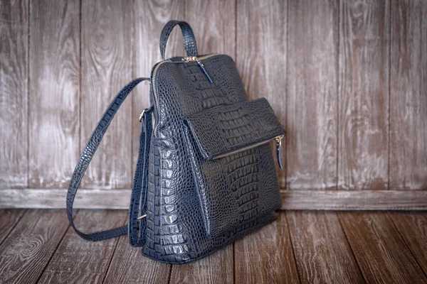 茶色の木製の背景の水色の革バッグ. — ストック写真