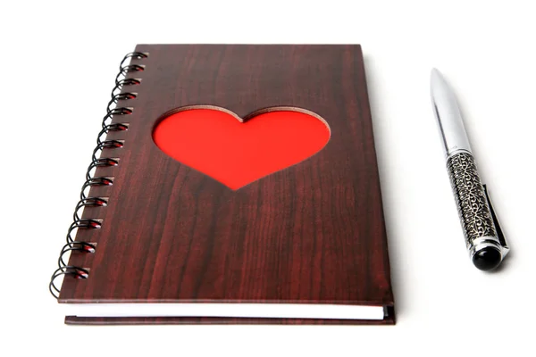 Wooden texture notebook with red heart and pen on white background — Stock Photo, Image