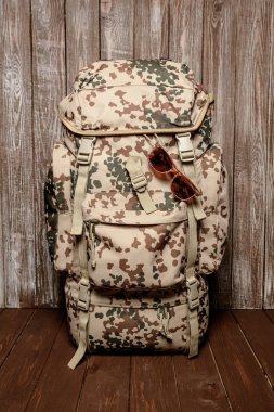 sırt çantası vintage gözlük ile ahşap bir arka plan üzerinde seyahat