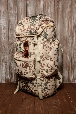 sırt çantası vintage gözlük ile ahşap bir arka plan üzerinde seyahat