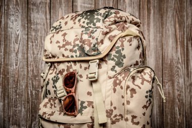 sırt çantası vintage gözlük ile ahşap bir arka plan üzerinde seyahat