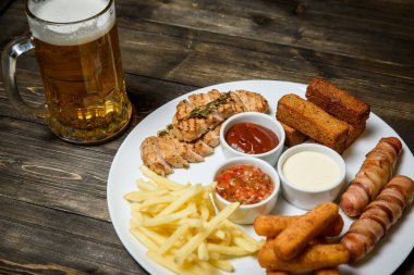 Ahşap arka plan üzerine bir bardak bira. ve snack.