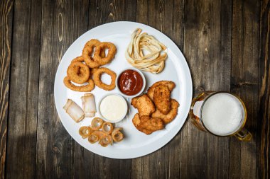 Ahşap arka plan üzerine bir bardak bira. ve snack.