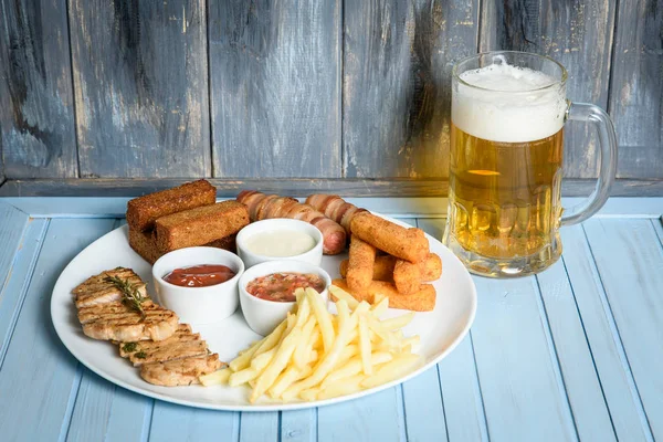 Beer in a glass on wooden background. and snack. — Stock Photo, Image