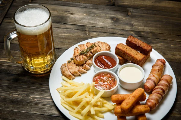 Beer in a glass on wooden background. and snack. — Stock Photo, Image