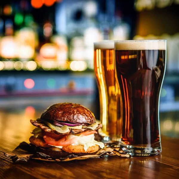Hamburger ve pub arka plan üzerinde koyu light bira.