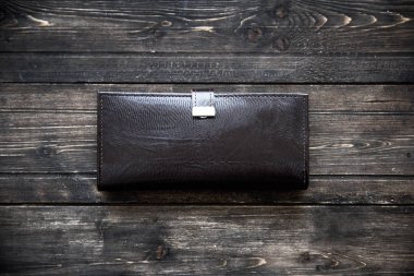 Ahşap arka plan üstten görünüm koyu deri cüzdan