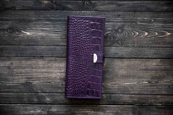 Фиолетовый кожаный кошелек на деревянном фоне — стоковое фото