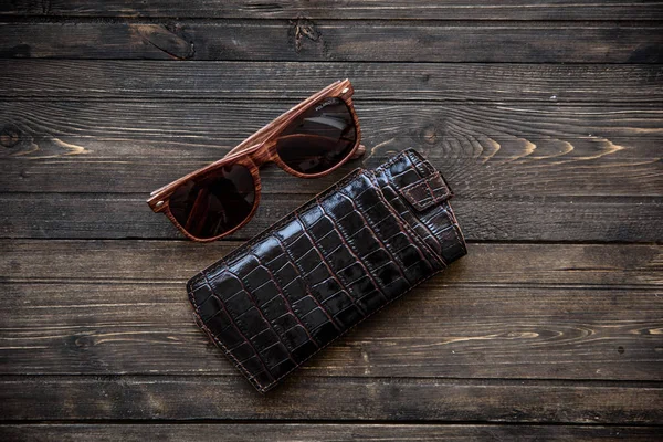 Модные очки с кожаной кобурой на деревянном фоне крупным планом — стоковое фото