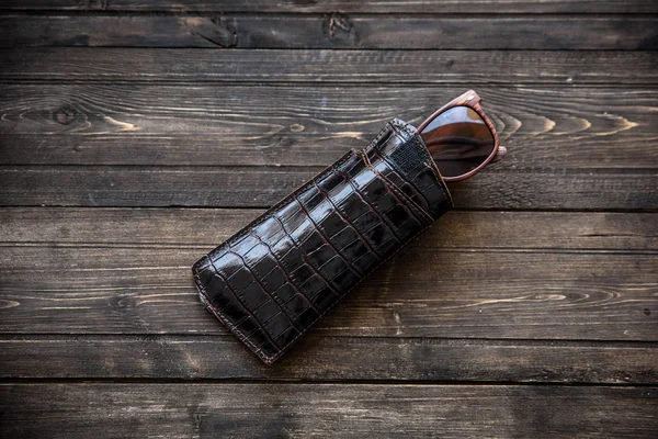 Óculos de moda com um coldre de couro em fundo de madeira close-up — Fotografia de Stock