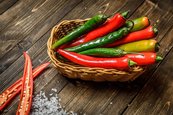 Červené a zelené chilli papričky na štítku na dřevěné pozadí — Stock fotografie