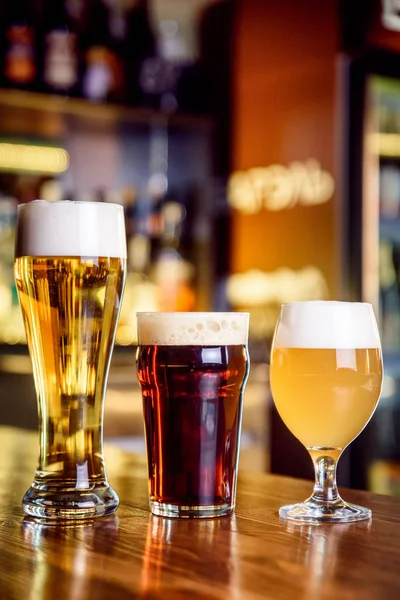 Verre de bière claire et sombre sur un pub avec fond bokeh — Photo