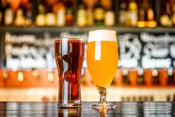 Verre de bière claire et sombre sur un pub avec fond bokeh — Photo