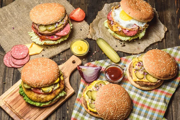 Mesa con diferentes hamburguesas — Foto de Stock