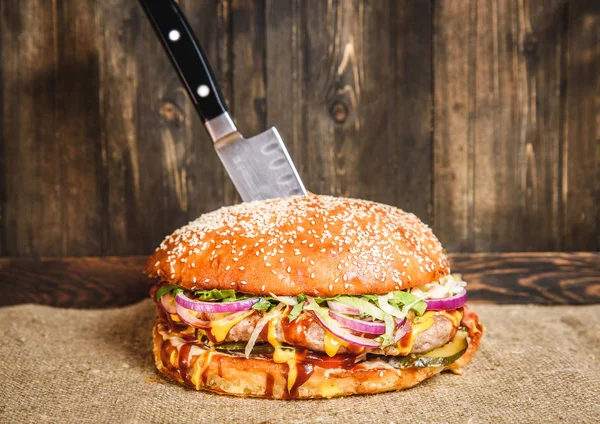 Hamburguesa apetitosa con cuchillo — Foto de Stock
