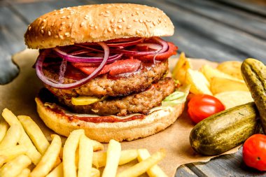 Burger dana pirzola ve taze sebze kızarmış patates ahşap arka plan üzerinde