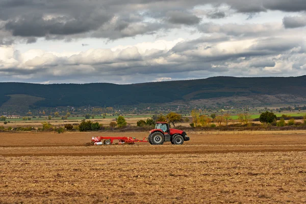 Traktor, orat pole za soumraku — Stock fotografie