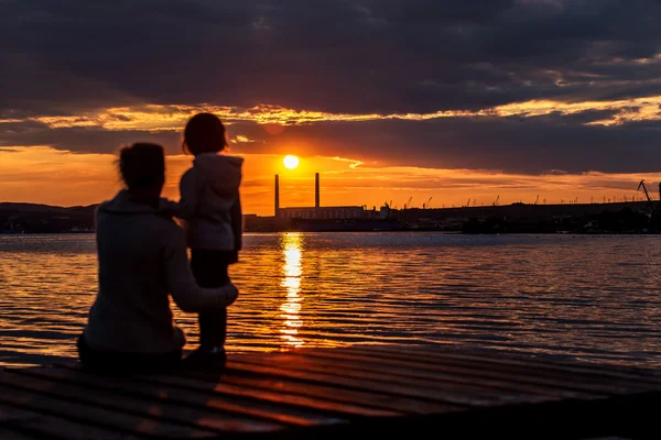 Mutter und Kind Silhouette bei Sonnenuntergang. — Stockfoto