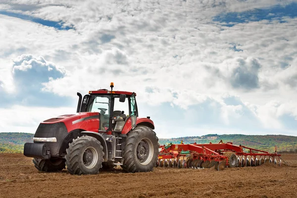 Moderní červený traktor v zemědělské oblasti. — Stock fotografie