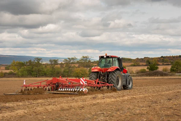 Farmář v traktoru připravuje půdu s kultivátorem seťového lůžka — Stock fotografie