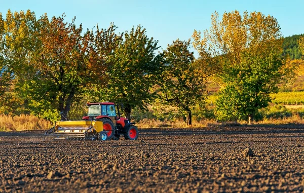 Αγρότης με τρακτέρ σπορά - σπορά καλλιέργειες στο γεωργικό τομέα — Φωτογραφία Αρχείου